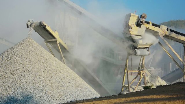 Video 1080p - Knapping machine unloads the crushed stone. All around in the dust.