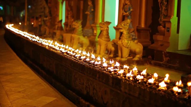 Video 1080p - Oil lamps in a Buddhist temple at night. Burma, Yangon