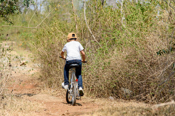 Naklejka premium Little boy ride bicycle on the rock road.