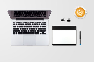 Fototapeta premium Laptop i filiżanka kawy na drewnianym stole. Widok z góry