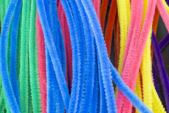This is a photograph of Blue,Green,Purple,Orange,Pink and Yellow pipe cleaners background