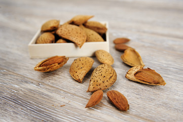Almonds and almond nuts on a rustic wood background 