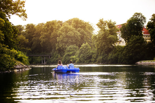 Rear view of friends pedal boating on channel against clear sky