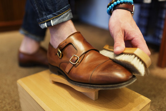 Man polishing leather double monk strap shoe