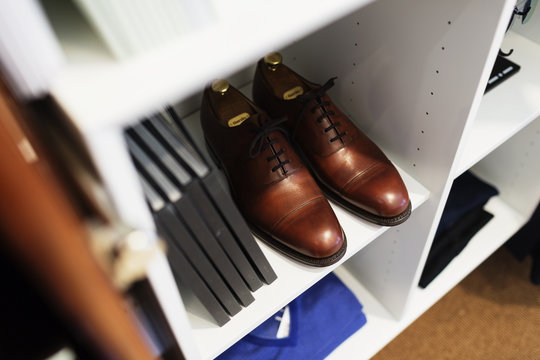 High angle view of brown shoes and books in shelf