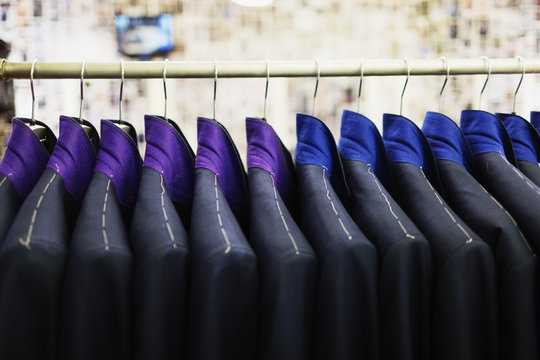 Row of unfinished blazers hanging on rack in tailor's shop