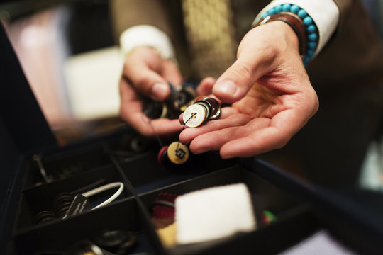 Close-up of fashion designer choosing buttons in drawer