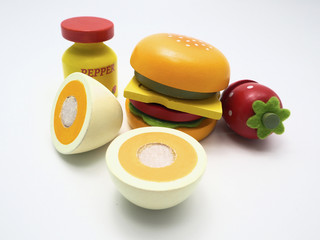 Wooden toys of hamburger, boiled egg, strawberry and pepper bottle, isolated