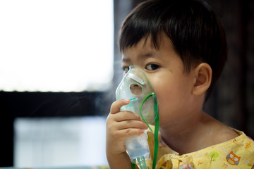 little boy wearing oxygen mask in hospital ward