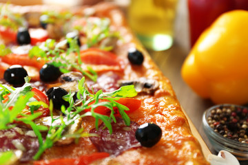 Rectangle delicious pizza and vegetables on the table, close-up