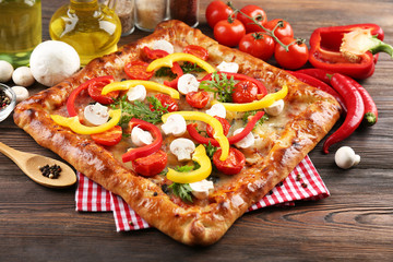 Freshly homemade pizza on wooden table closeup