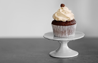 Tasty cupcake on light background