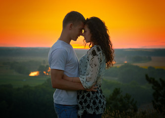 romantic couple at sunset on bright yellow sky background, love tenderness concept, young adult people