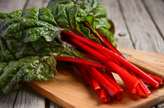 Fresh red chard leaves on wooden background, selective focus, copy space