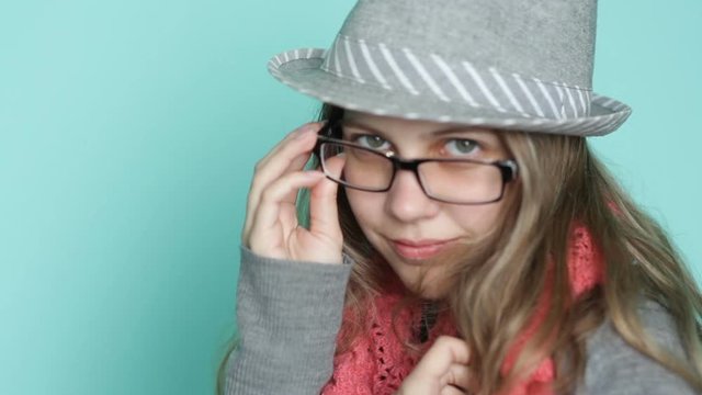 pretty young beautiful woman in a hat and glasses posing