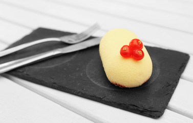 Dessert with red currant on black slate plate