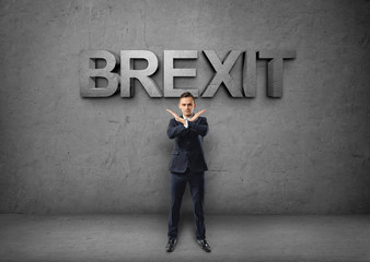 Young businessman making X sign by his arms on the concrete backround with 'brexit' word