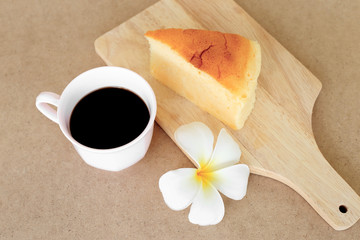 Pieces of Japanese style Cheesecake and cup of black coffee on w