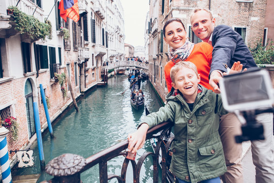 Happy family take a self photo on the bridge over Venecian chann