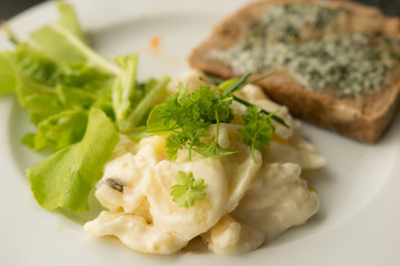 Kartoffelsalat, Gartensalat, Kräuter und Brot mit Kräuterbutter
