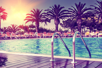 Fototapeta na wymiar Concepto de verano,piscina exótica en el hotel con palmeras.Relax y bienestar.Vacaciones en el mar