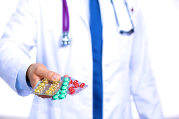 A young doctor holds the patient's hand with pills