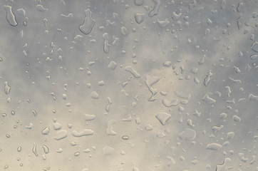 Water drop on glass over hazy sky