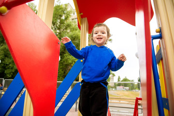 Fototapeta na wymiar child slides down a slide at the playground