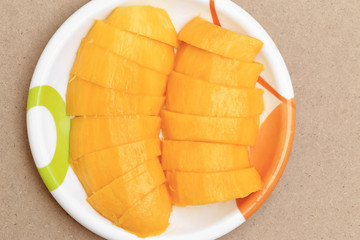 Yellow mango tropical thai fruit in plate, top view.
