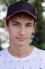 Close up portrait of a cute teenager in a baseball cap.