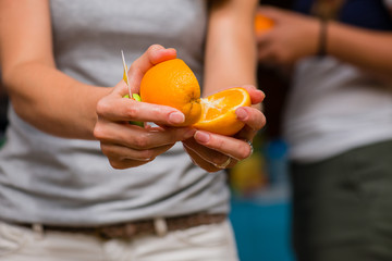 close-up of a girl cutting orange outdoors