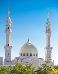 Купола белой мечети на голубом небе