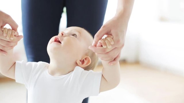 happy little baby walking with mother help at home 15