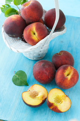 Ripe peaches in basket on wooden background