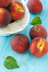 Ripe peaches in basket on wooden background