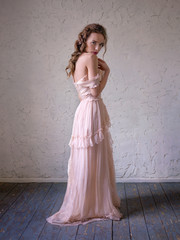 Fashion portrait of beautiful woman in a long pink dress.