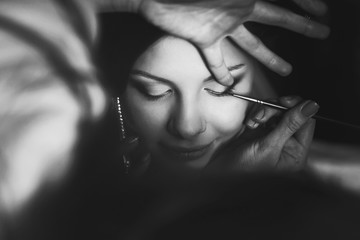 Obraz premium Artist does an eye makeup on tender lady's face