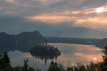 Pink cloudy sunrise on the lake Bled, view on the island and Julian Alps, Slovenia, Europe