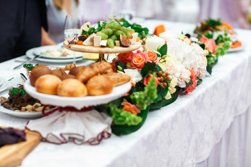 Fruits, cheese, bread and other appetizers lie between decoratio