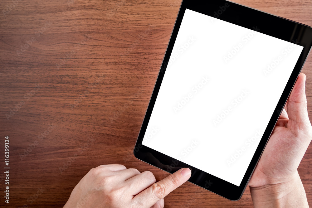Poster hand touch on empty screen of tablet above brown table top view,