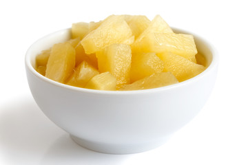Naklejka na ściany i meble Canned pineapple pieces in a ceramic bowl isolated on white.