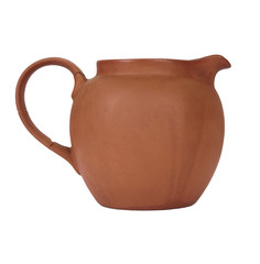 A small ceramic water jug with a broken handle isolated on a white background