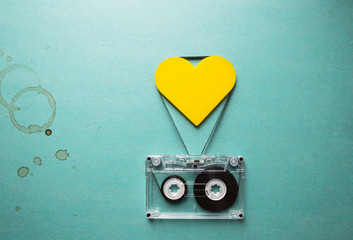 love to music, audio cassette with yellow heart and coffee stains on a green background