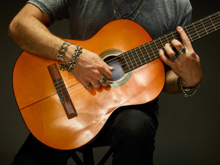 Fototapeta na wymiar The guy playing an acoustic guitar.