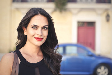 Smiling dark-haired woman wearing red lipstick