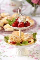Cream puffs cakes or profiterole filled with whipped cream served with strawberries in plateau