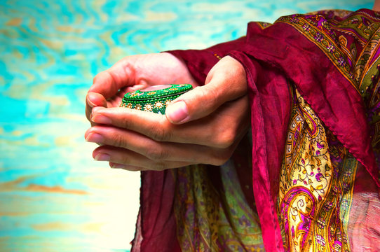 Woman's hands holding green oriental casket