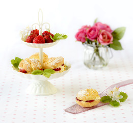 Cream puffs cakes or profiterole filled with whipped cream served with strawberries in plateau