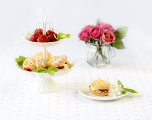 Cream puffs cakes or profiterole filled with whipped cream served with strawberries in plateau