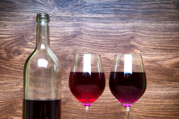 Wine glass and bottle on a wooden background